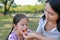 Closeup Asian mother feeds some orange fruit for her daughter in the garden outdoor