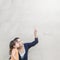 Closeup asian mother pointing her finger and tell her son to look at the copy space of a picture on marble stone wall textured bac