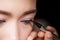 Closeup asian woman applying eyeliner on eye