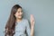 Closeup asian woman holds up three fingers with smile face on blurred cement wall textured background with copy space