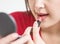 Closeup asian woman are making up by lipstick in cosmetic concept