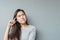 Closeup asian woman sitting and look at space with thinking face on blurred cement wall textured background with copy space