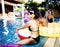 Closeup of asian woman sitting by the pool with diverse friends