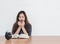 Closeup asian woman sitting for read a book with scary face and shock emotion on wood table and white cement wall textured backgro