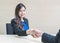 Closeup asian woman success to deal business with someone with happy face in meeting room on blurred wooden desk and wall textured
