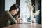 Closeup asian woman use smartphone for read online news at the wooden counter desk in coffee shop on blurred coffee shop view back