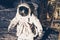 Closeup of an astronaut wearing a white astronaut costume walking on the moon