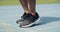 Closeup of athlete tying shoe laces and jumping in place before running and exercise. Feet of runner warming up and