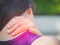 Closeup athletic young woman touching her neck by painful injury
