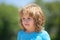 Closeup attractive kids face. Child emotions concept. Portrait of young smiling kid outdoor. Blur background.