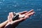 Closeup of a baby tortoise in female hands against a shining ocean