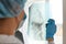 Closeup back side shot of woman doctor in medical cap and blue gloves, radilogist holding x-ray, holding radiology picture,