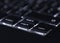 Closeup of backlit computer laptop keyboard selective focus on end key ideal for technology night hacker standout