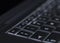 Closeup of backlit computer laptop keyboard selective focus on escape key ideal for technology night hacker standout