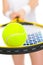 Closeup on ball on racket in hand of tennis player