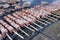 Closeup of barbecues on sticks on a grill under the sunlight