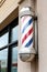 Closeup barbershop pole on a wall in the sun
