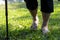 Closeup of barefoot feet,asian senior woman walking barefoot on grass in sunny summer,elderly female people with walking stick,