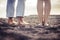 Closeup barefoot two couple of caucasian feet portrait on the beach. viewed from behind, love and intimate concept for young