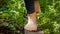 Closeup of barefoot woman walking on grass and wooden plank board in garden. Concept of freedom. loving nature and