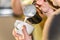 Closeup barista in preparing proper cappuccino pouring milk froth in a cup