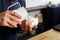 Closeup of barmen pouring milk to cappuccino cup