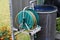 Closeup of a barrel of water and a watering hose in a garden at daytime