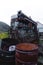 Closeup of barrels of fuel oil in background of metal machinery