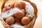 Closeup of a basket with organic chicken eggs and feathers. Defokus in the background. Eggs for easter.