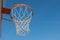 Closeup basketball hoop, basket with white net and blue sky in background