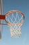 Closeup basketball hoop, basket with white net and blue sky in background