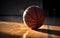 Closeup of a basketball on a scuffed up court floor with dramatic sunlight