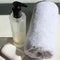 Closeup of bathroom accessories. Bottle of transparent hand sanitizer antiseptic, white terry towel, and soap.