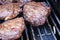 Closeup of BBQ steaks cooking on a grill