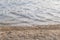 Closeup beach of freshwater lake with water textured background in evening