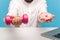 Closeup bearded man holding out hands with pink dumbbell and sweet donut with icing to camera sitting at workplace with laptop,