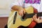 Closeup beautiful acoustic guitar being played by hispanic woman sitting down, musician concept