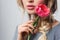 Closeup of beautiful attractive fashion model with sensual lips holding tulip with tenderness with her beautiful hands and