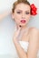 Closeup on beautiful blonde young woman with blue eyes and red lips lying in spa bath with milk and looking at camera