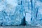 Closeup of beautiful blue ice , cracks and caves of large glacier enters the ocean