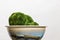 Closeup of beautiful mossy plant in a ceramic bowl on a white background