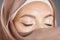 Closeup of a beautiful Muslim woman covering her beauty with her scarf and showing shimmery eyeshadow. Face of a