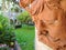 Closeup of beautiful terracotta face wall decor and gardens with mansion in background