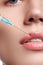 Closeup of beautiful woman gets injection in her lips. Full lips. Beautiful face and the syringe (plastic surgery and cosmetic inj