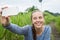 Closeup of beautiful woman taking a selfie on smart phone outdoors in summer. Young woman photographing herself smiling.