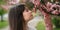 Closeup beautiful young brunette girl 11-12 years under the flowering pink tree