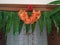 Closeup of Beautifully Decorated Firecracker or Kanakaambara Flower and Mango Leaves Toran in front of the Entrance door during