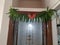 Closeup of Beautifully Decorated Firecracker or Kanakaambara Flower and Mango Leaves Toran in front of the Entrance door during