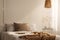 Closeup of bed with beige blanket and linen pillow in minimal bedroom interior, real photo