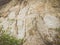 Closeup of beige aged shabby cliff cracks. Light colour stone rock texture of mountains. Concept of geology and